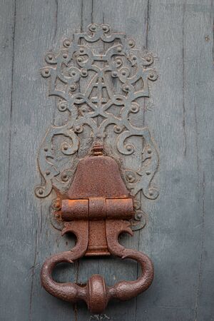 Old door knocker on a wooden door in the old town of Nancyの写真素材