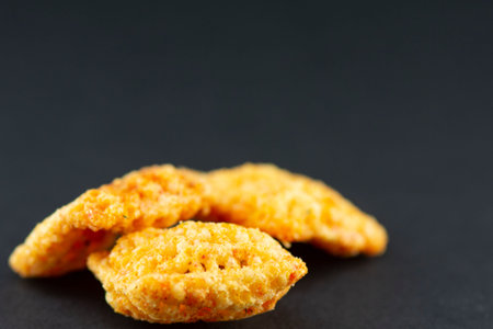 Potato chips with salt, cheese and garlic on a black background