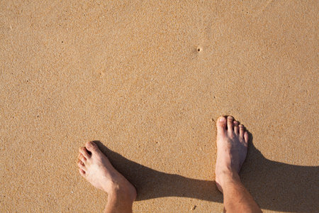barefeet in sand on beach in summer holidays relaxing