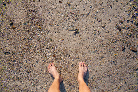 barefeet in sand on beach in summer