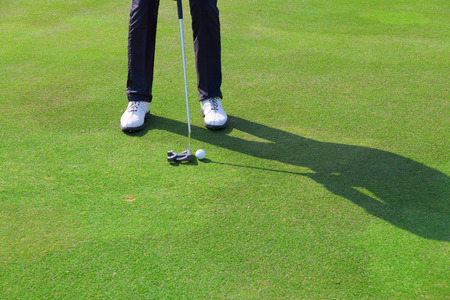 golfers feet with ball in front of the holeの写真素材