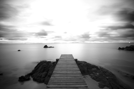 Wooden pier at the beach in the morning lightの写真素材