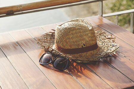 old weave hat and sunglasses on the wood tableの写真素材