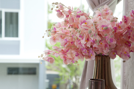 Bouquet of pink flower in vase near the windowの写真素材