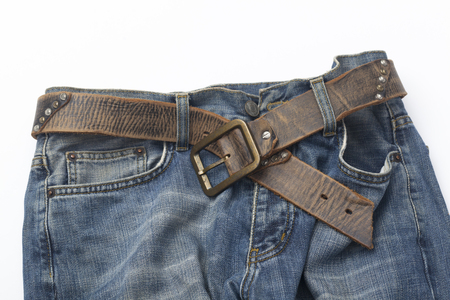 Blue jeans and leather belt on white background.の写真素材