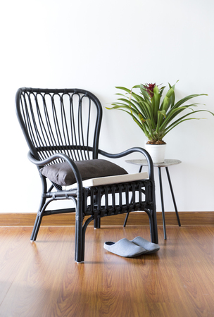 black rattan Chair in interior setting by the windowの写真素材