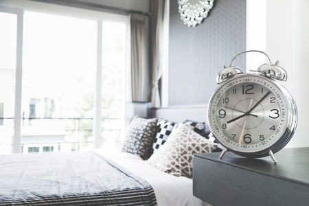 alarm clock on table in bedroom at homeの写真素材