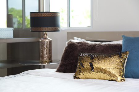 Stylish white bedside table with modern lampの写真素材