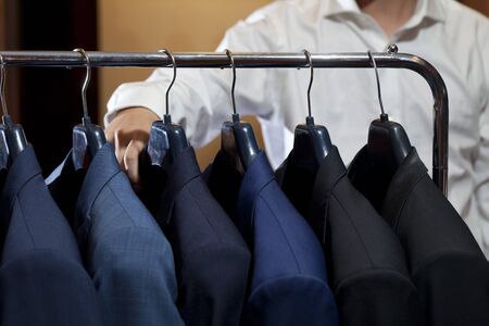 Row of men's suits hanging in closet.の写真素材