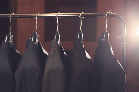 Row of men's suits hanging in closet.の写真素材