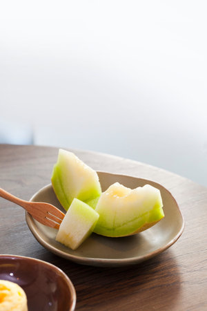 Juicy slice cantaloupe melon on ceramic dishの写真素材