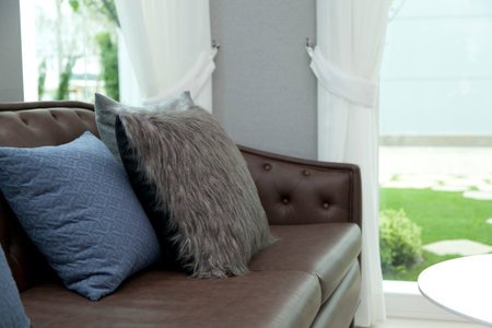 blue cushion on leather sofa