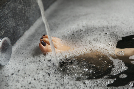 close up of woman 's leg taking a shower in a bathtubの写真素材