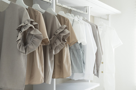 White wardrobe with shirts and pants hangingの写真素材