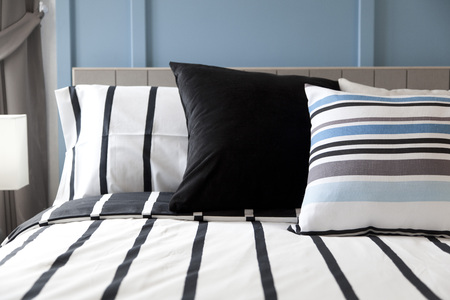 Stylish bedroom interior design with black patterned pillowsの写真素材