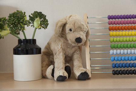 Cozy bedroom interior with puppy doll and pillows on bedの写真素材
