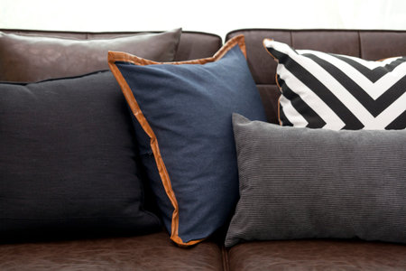 row of blue and black pillows on leather sofa