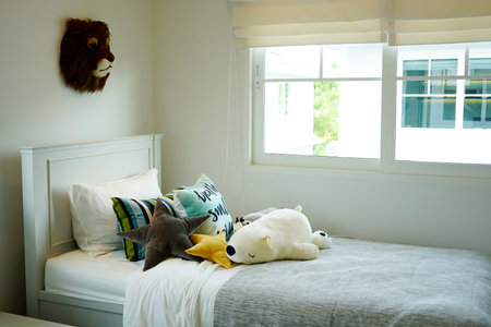 kid's bedroom with colorful pillows on bed with dolls and toys interior design concept