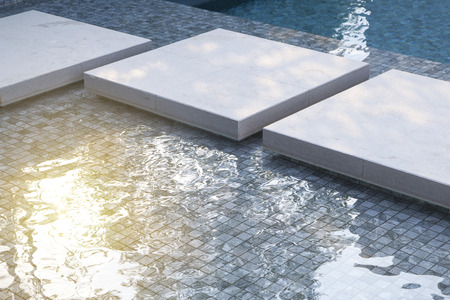 close-up edge of the swimming pool with blue mosaic tilesの写真素材