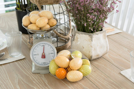 Many fruit rest on tab;e beside scales.