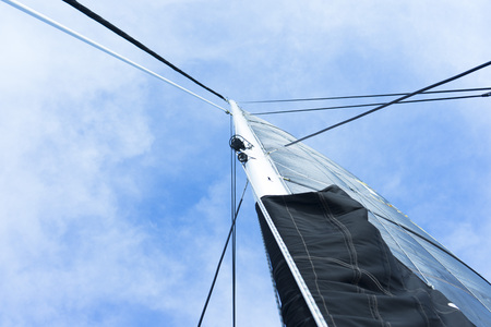 yacht mast with a white sailの写真素材