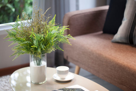 green plant vase on table and brown sofa in modern living room