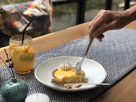 Yellow lemon cake with woman hand.の写真素材