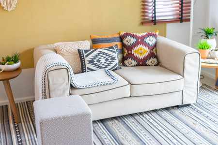 colorful pillow with native american pattern on biege sofa in living room.
