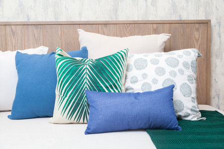 close up of set of white, blue and grey pillows on white Sofa