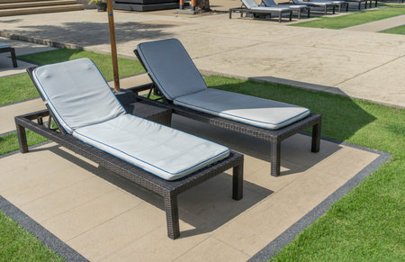 Daybed sun lounger chair by poolside with towel and umbrella