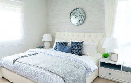 beach blue pillow on bed with side table lamp and large clock on wall in bedroom