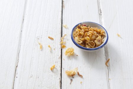deep fried garlic in a cup on wood table, food ingredient.の写真素材