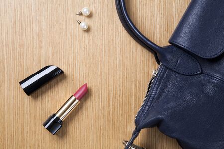 lipstick and black round bag on wood tableの写真素材