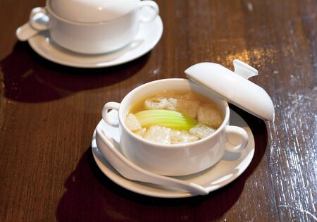 Chicken soup with Chinese herbs and bamboo in a white bowl.の写真素材
