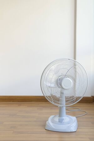 Table electric fan sit on the wooden floorの写真素材