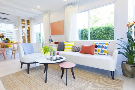 Modern design of living room with yellow,blue and orange pillow on sofa. Modern coastal home interior.の写真素材