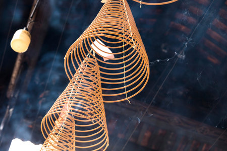 Burning spiral incense sticks hanging from the ceiling of Chua Ba Thien Hau pagoda in Ho Chi Minh,...