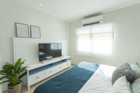 Interior of master bedroom with large window and big TV on the wall.の写真素材