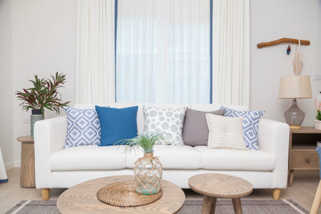 White sofa with many blue pillows in cozy living room