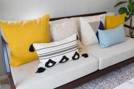 Yellow,blue and white pattern pillow on white sofa.