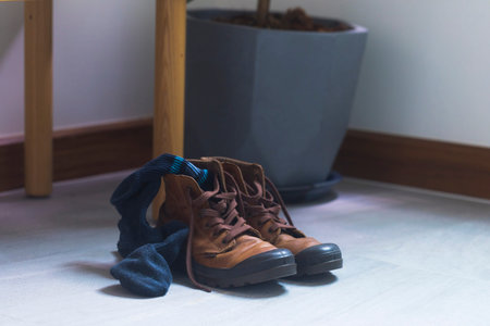 View of leather boots and socks used and put at foyer at the home.