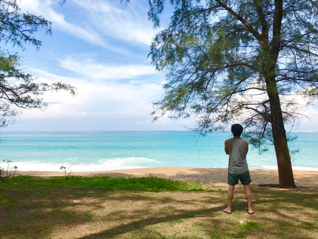 Asian man tourist standing on tropical island beach