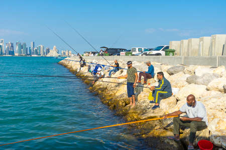 man fishing and relaxing at Dhow Harbour in Doha, Qatarのeditorial素材