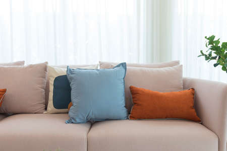Cozy white sofa with colorful suede pillows in modern living room.の写真素材