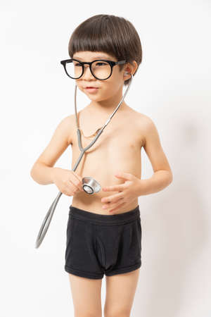 Asian boy with glass smiling and plays stethoscope on white background. Healthcare for Baby and skills develop concept.の写真素材