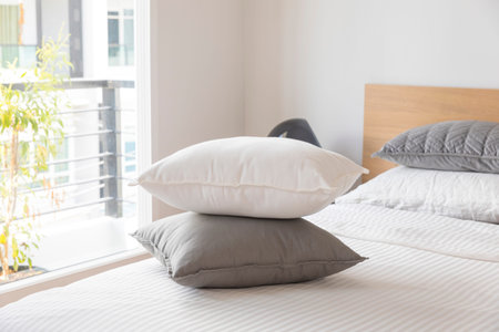 Minimal contemporary style bedroom with white fabric bed set and side table lamp.の写真素材