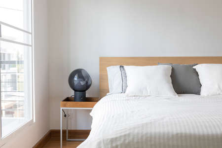 Minimal contemporary style bedroom with white fabric bed set and side table lamp.の写真素材