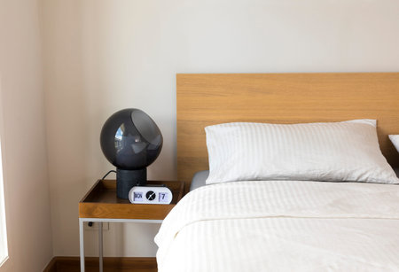 Minimal contemporary style bedroom with white fabric bed set and side table lamp.