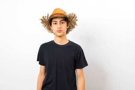 portrait of a white teen boy with straw hat standing on white background.の写真素材