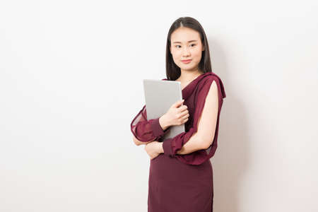 Happy beautiful asian business woman using tablet isolated on white background.の写真素材